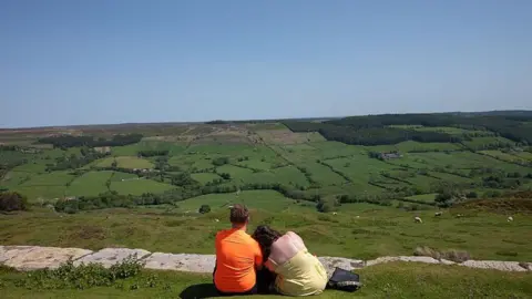 A couple enjoy the view over the North Yorkshire Moors