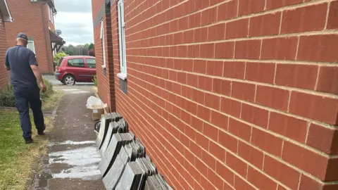 Mark Pengelly Grey tiles lined up against a brick wall