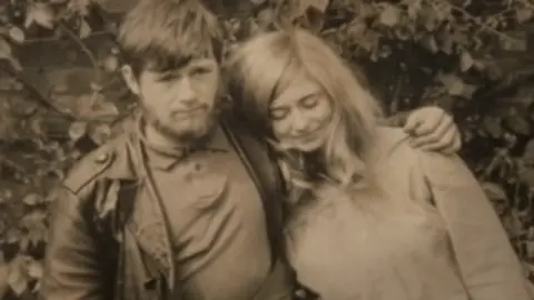 Tom Marshall A sepia image of a man with a beard and a woman with long hair 