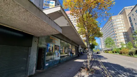 Local Democracy Reporting Service The exterior of the former Tales of Robin Hood attraction in Nottingham. Maid Marian Way, lined with trees, is seen outside of the building and towards the right of the image.