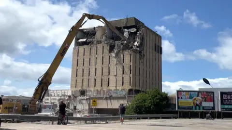 A high-reach excavator starts to demolish Blackpool's former Bonny Street police station.