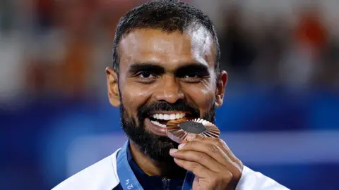 Reuters India's goalkeeper #16 Sreejesh Parattu Raveendran poses on the podium with his bronze medal af