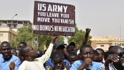 People protesting against the US presence in Niger hold a poster that says: "US army, you leave, you move, you vanish, no bonus, no negotiation"