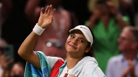Emma Raducanu waves to the Wimbledon crowd