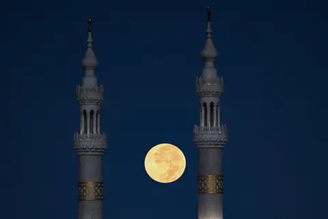 KHALED DESOUKI / AFP / GETTY IMAGES The full moon is visible between two towers. 