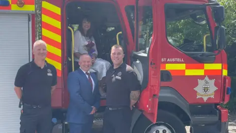 St Austell Community Fire Station Firefighters Andy Brier and Martin Giles with married couple David Martin and Rebekah Hill