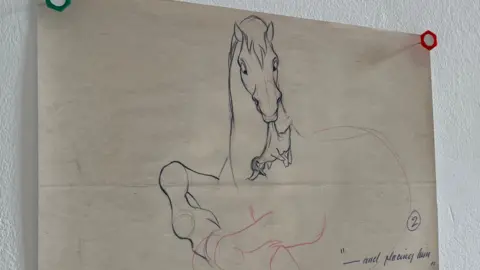 Tom MacDougall/BBC A rudimentary sketch of a horse holding a duck in its mouth. The head of the horse and the duck are most detailed, and drawn in pen. The horse's body is more loosely portrayed in red pencil.