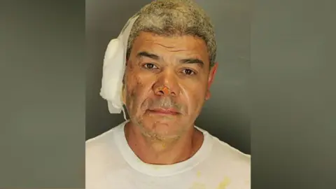 A mug shot of Mr Soliman wearing a white shirt with bandage on his ear