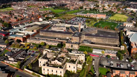 Getty Images/Ballygally View Images An aerial view of the rear of Crumlin Road Courthous with Crumlin Road Gaol behind it on the opposite side of the road. They are in a built-up area, surrounded by houses and commercial buildings.