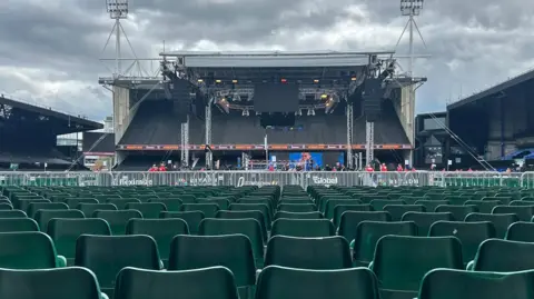 Dino Cabras Seats in the foreground at Portman Road, with a stage in the centre of the pitch, that has a boxing ring in the middle with big screens that will broadcast the fight. Behind the boxing ring is one of the stands at the stadium.