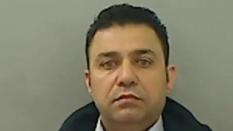 Mugshot of Mohammed Zada; a man with dark hair