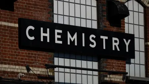 Reuters A red brick building with a blacked out window. A black and white sign on the building reads "Chemistry".