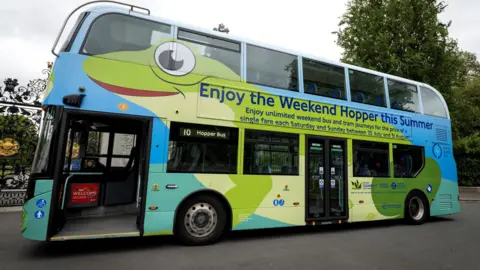 A green bus carrying slogans advertising the Hopper fares