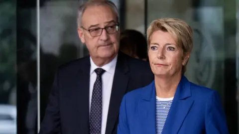 AFP via Getty Images A gloomy looking Karin Keller-Sutter, with economy minister Guy Parmelin, leave the US Department of State after talks in August.