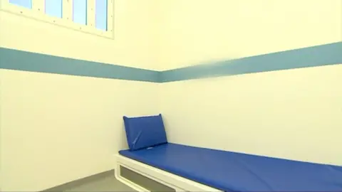 BBC Look East The interior of a custody sweet, a room with white walls and a narrow blue bed