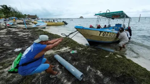 Reuters Men pull a boat from the water as Tropical Storm Helene approaches the Yucatan Peninsula, in Cancun, Mexico September 24, 2024.