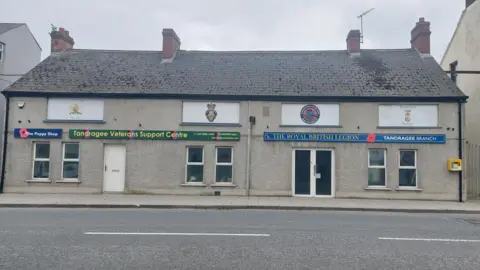 The Royal British Legion building in Tandragee and the Tandragee Veterans Support Centre.. Two grey buildings next to each other, you can also see the logo of both buildings