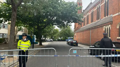 BBC Two police officers behind railings and police tape