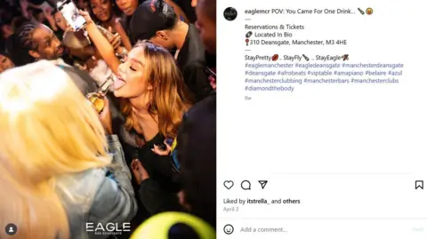 LDRS/Eagle A blonde woman pours a drink into another woman's mouth in a crowded bar