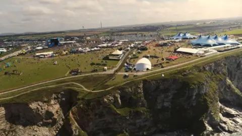 Cornwall Council The cliff edge that the Boardmasters festival is hosted on, showing the many tents, arenas and fair-ground rides such as a ferris wheel, that are on the site.