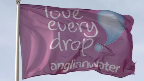 A purple flag with the slogan "Love every drop" and the Anglian Water logo on it.