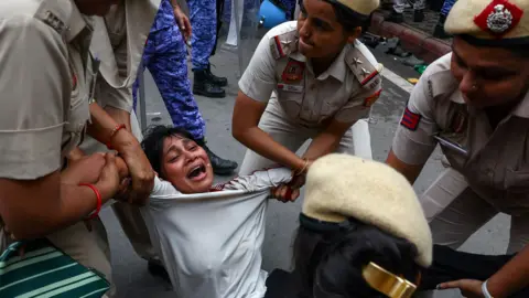 Reuters Police officers remove a protester as supporters of India's Cockroach Janta Party demonstrate on the opening day of the Indian parliament's monsoon session, demanding the resignation of Education Minister Dharmendra Pradhan over exam paper leaks, in New Delhi, India, 20 July, 2026. REUTERS/Anushree Fadnavis TPX IMAGES OF THE DAY
