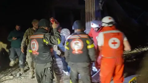 Lebanon Civil Defence Image shows rescue workers at the scene of a strike that hit two Lebanese journalists.