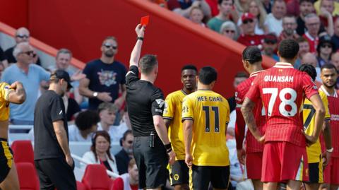 Nelson Semedo is show a red card as Liverpool and Wolves players surround him