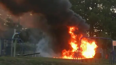 Peter Ellis/Our Bassetlaw A fire burning in the centre of a playground with a thick plume of smoke rising up