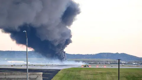A large plume of dark grey smoke marks where a UPS cargo plane crashed near Louisville Muhammad Ali International Airport on 4 November 2025