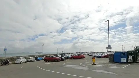 Google Cars parked at a car park in Guernsey. Water is in the background.