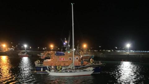 A photo showing the rescue underway with the lifeboat rafted to the yacht