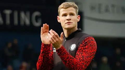 Rob Atkinson applauds fans on the field during Bristol City's game against West Brom