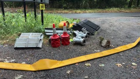 A flattened pump with some cones and metal fastening next to it.