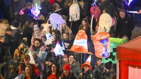 Stuart Walker A parade displaying iconic Scottish emblems including the flag and Irn Bru