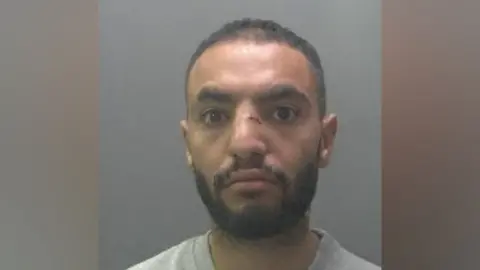 Cambridgeshire Constabulary A custody photo of a man with a cut on his nose