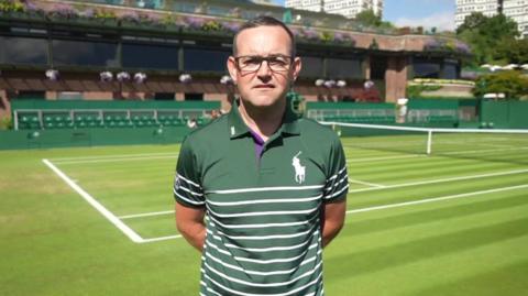 Steven Davies standing on a tennis court at the All England Tennis Club in Wimbledon