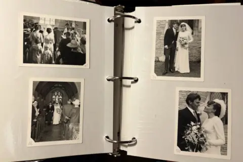 A photo album with four black and white photos of a couple's wedding day.