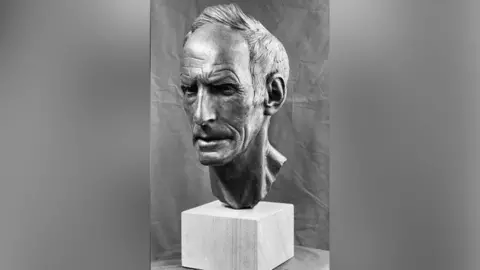 A black-and-white photo of the sculpture of Joss Naylor's head and neck. The face has a stern expression.