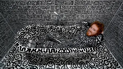 PA Media British artist Sam Cox, aka Mr Doodle, reveals the Doodle House, a twelve-room mansion at Tenterden, in Kent, which has been covered, inside and out in the artist's trademark monochrome, cartoonish hand-drawn doodles.