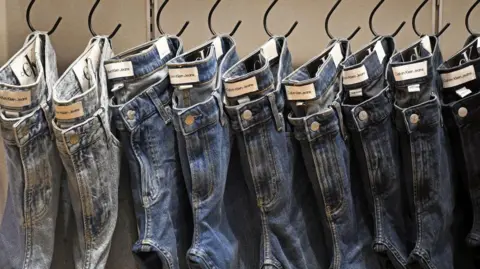 Getty Images Calvin Klein Jeans of different styles hanging in a row in pegs