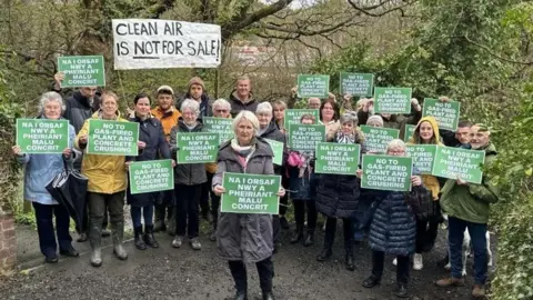 File photo: More than a dozen campaigners wave placards in English and Welsh, with one sign saying 'clean air is not for sale'