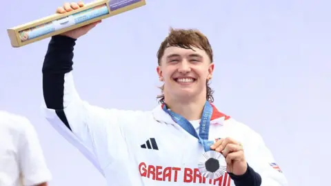 PA Media Kieran Reilly smiling in Team GB top with silver medal