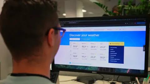 An over the shoulder shot of a man looking at the new Bureau of Meterology website