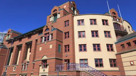 Leeds Magistrates' Court, a red-brick building with a cream-coloured brick section.