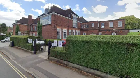 Google St Peter's School in York, a red brick secondary school building with hedge and gates to the front