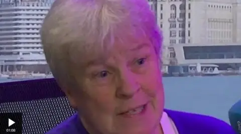 A woman with short grey hair is talking in the BBC Radio Merseyside studio