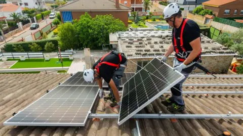 Getty Images Solar panels being installed on a house in Madrid