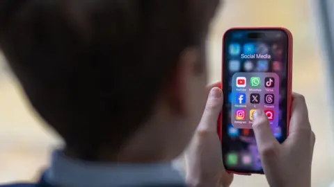 Generic image of a school child using a smartphone to look at social media