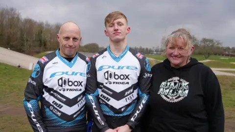 BBC/SHAUN WHITMORE Family photo of dad Alan Hill on the left, Jared in the centre and mum Abi Hill on the right at the BMX track at Sloughbottom Park, home to Norwich Flyers.